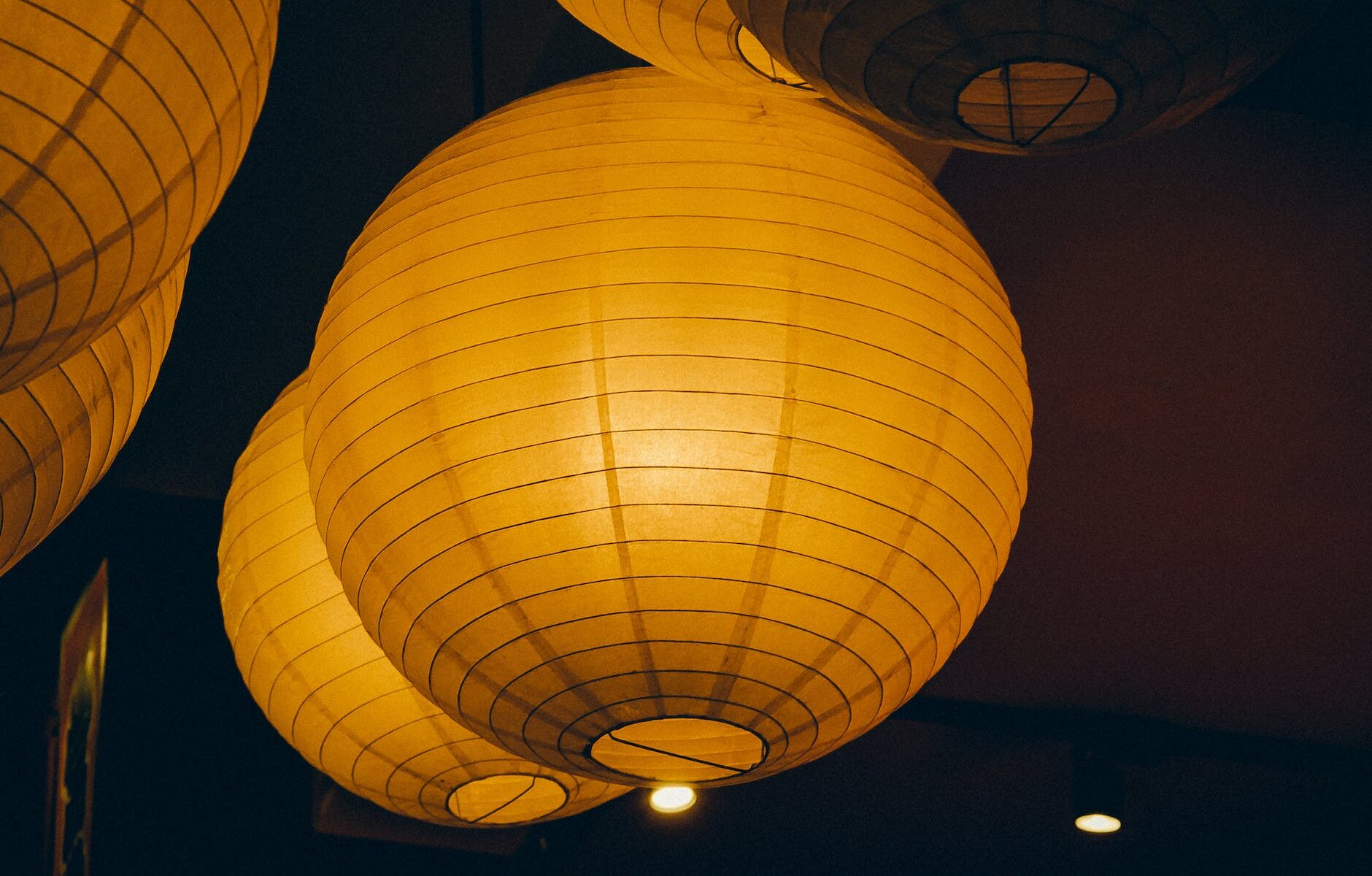 orange paper lanterns hanging in the dark